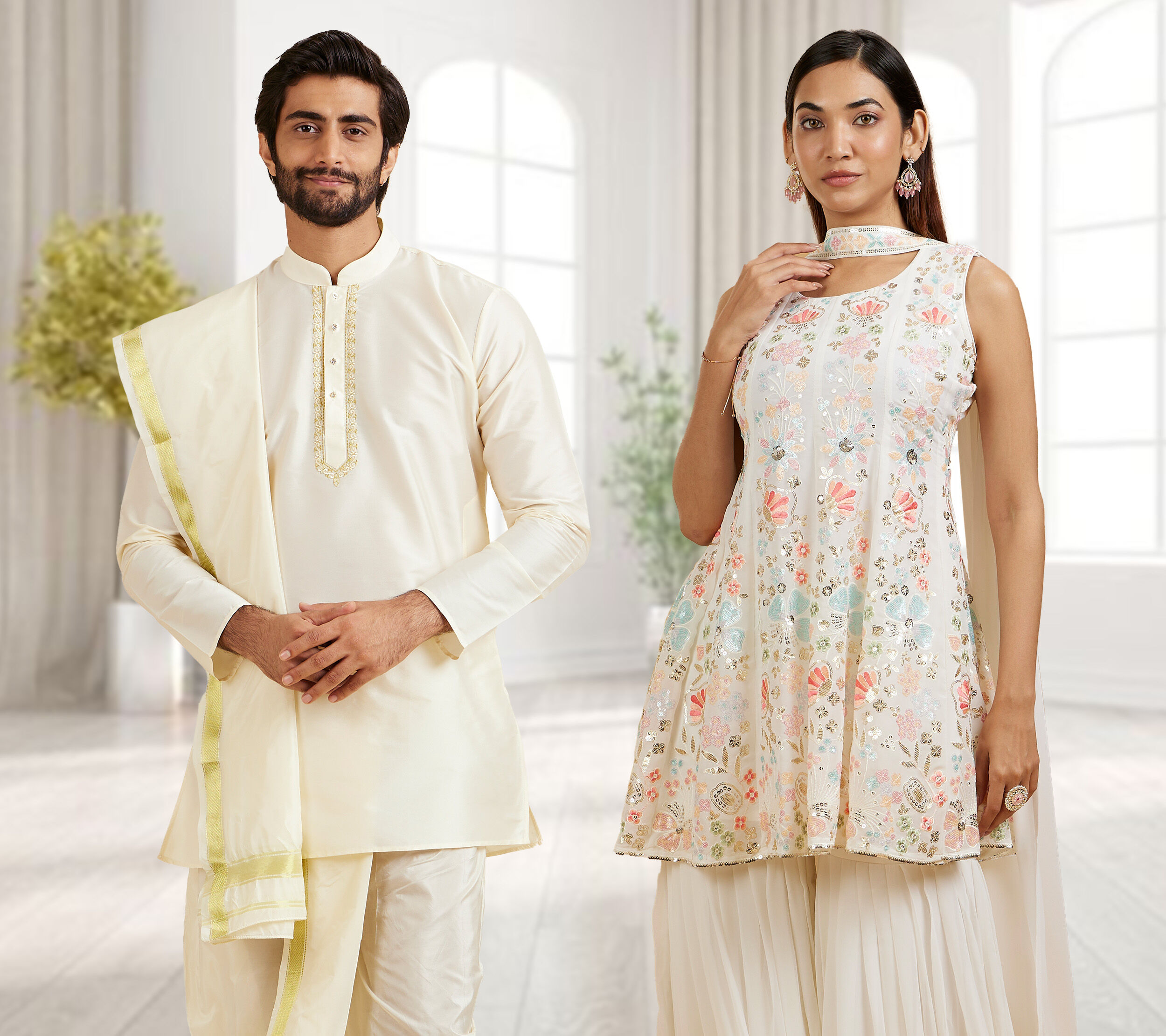 Couple dressed in coordinated white traditional outfits for a festive Janmashtami celebration.